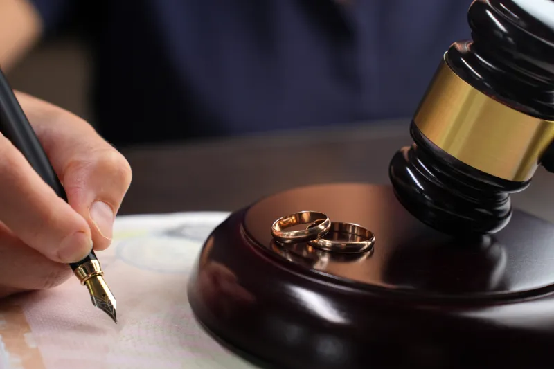 Close-up of a woman signing a divorce agreement
