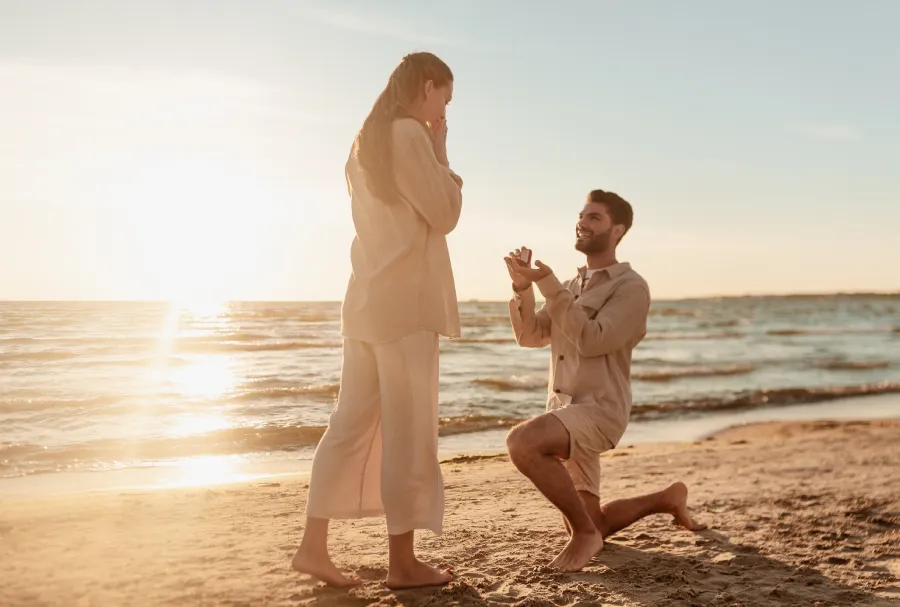 man proposing to woman on beach