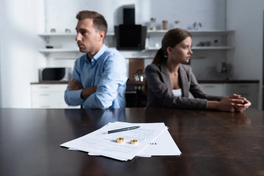 couple sitting at table with divorce documents