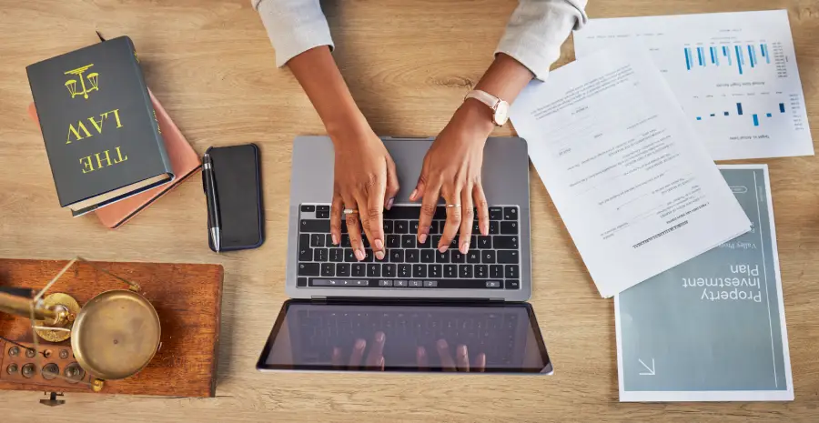 woman and laptop typing with divorce case and notes