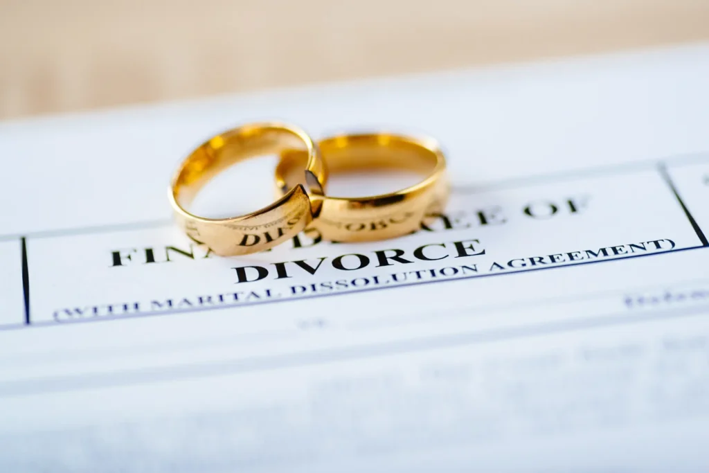 Two broken golden wedding rings divorce decree document