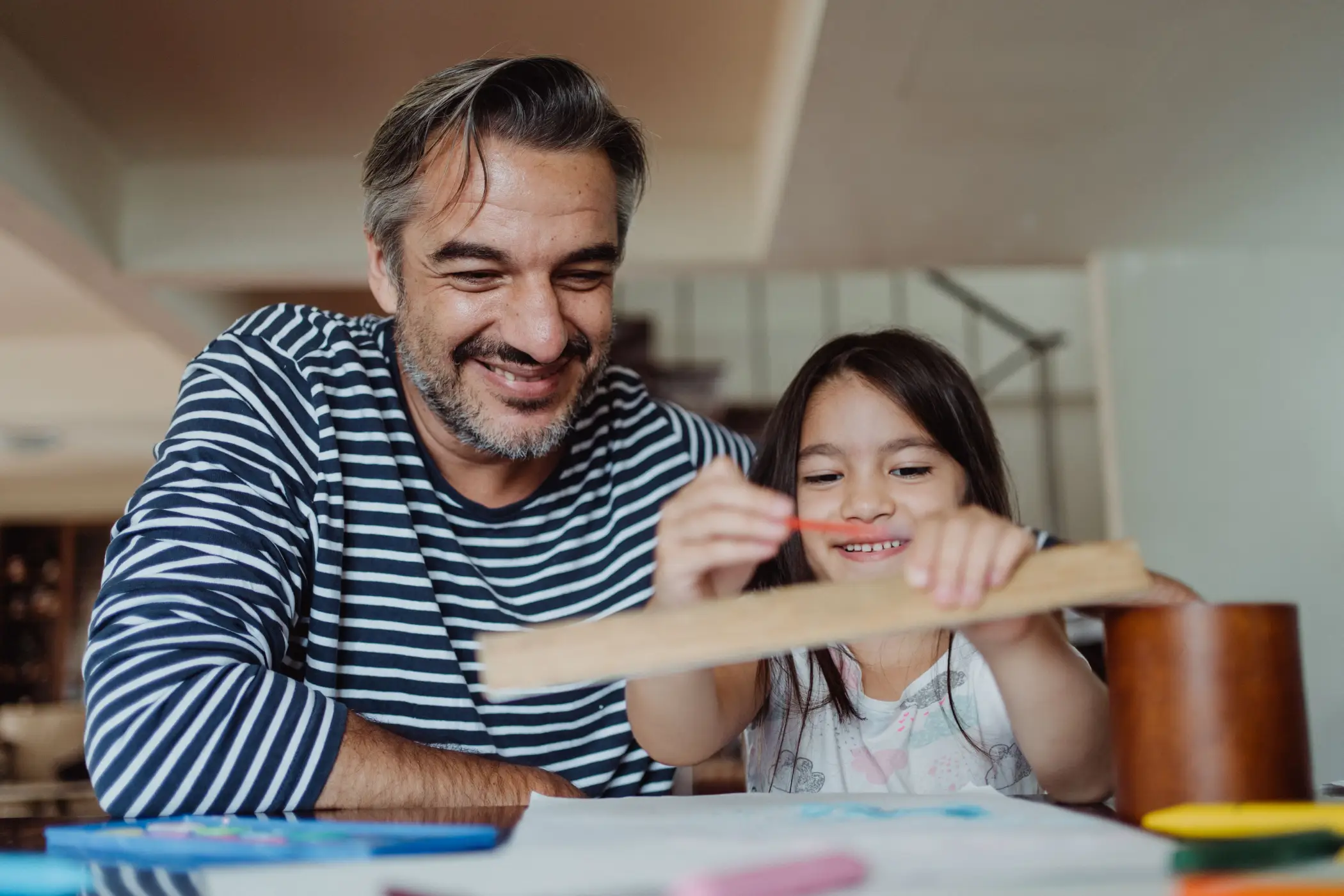 father supports daughter with art project